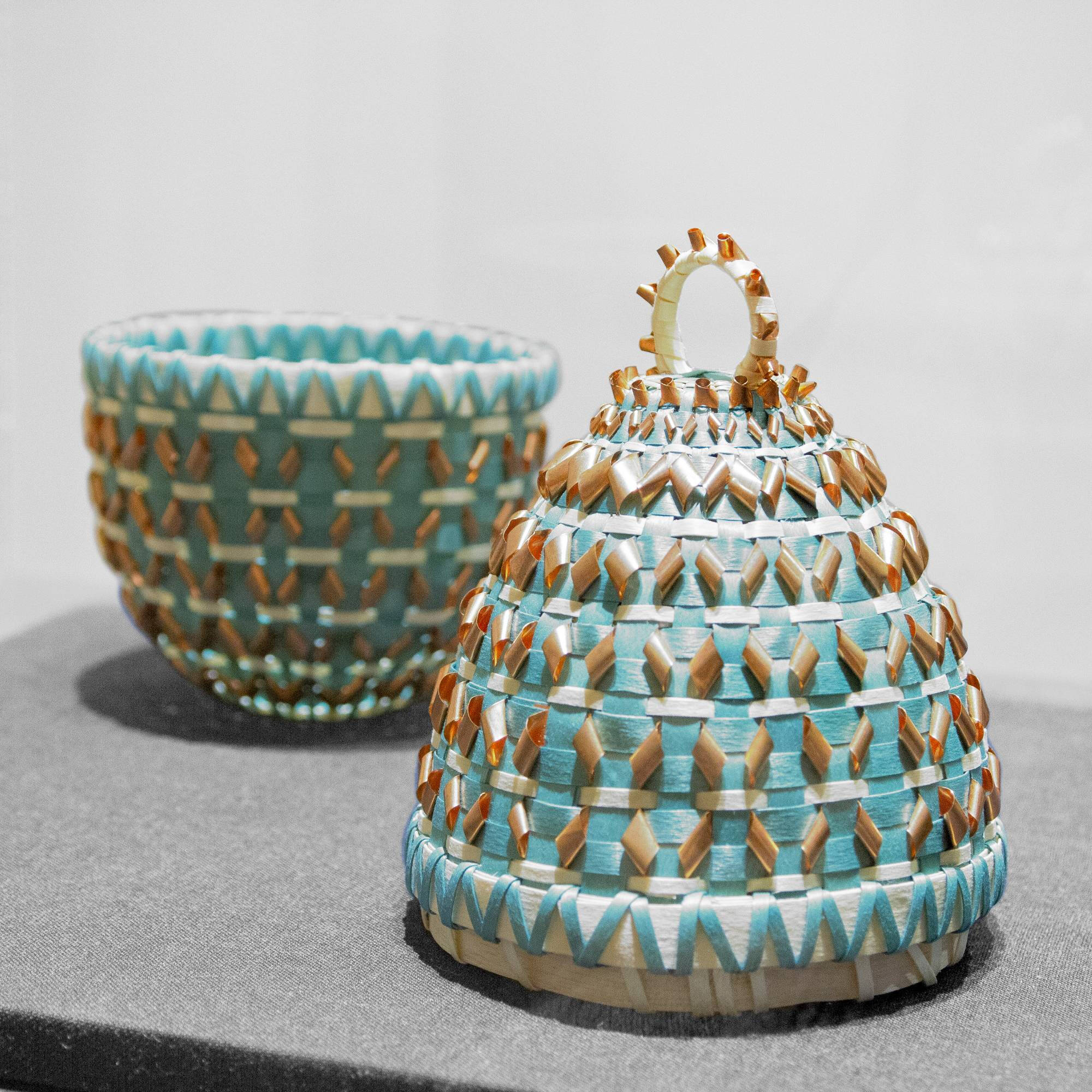 Woven basket with lid, some is blue.
